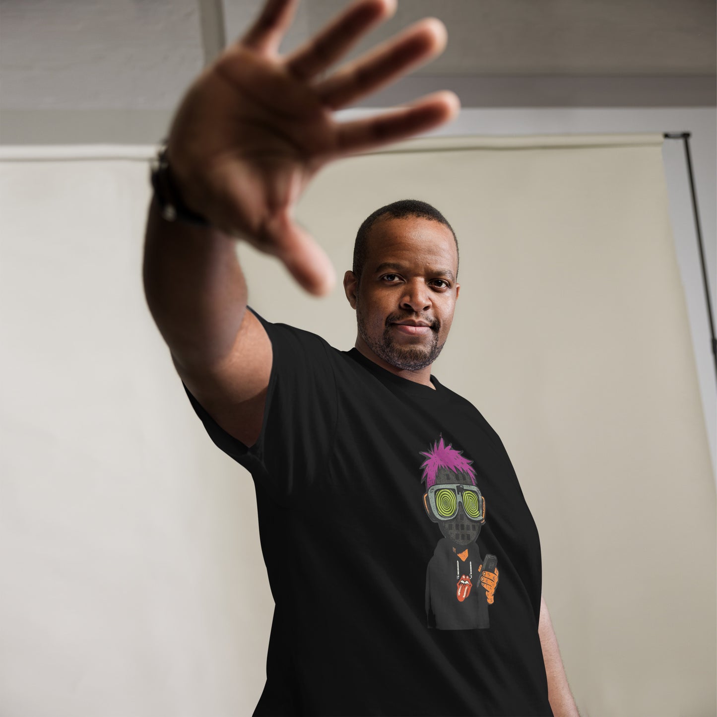 Man wearing a black t-shirt with a colorful graphic design, standing against a plain background.